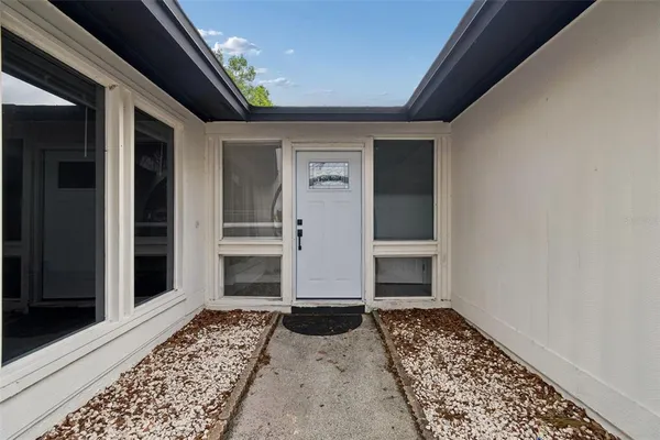 a view of empty room with wooden floor and ceiling fan