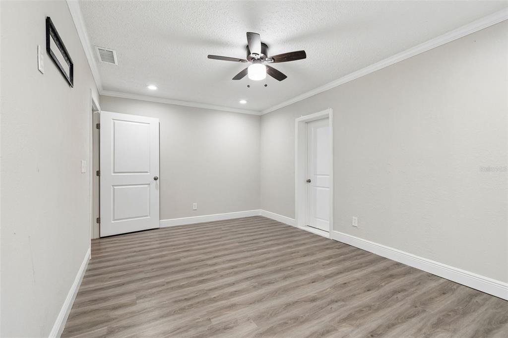 7403 Spring Court Tampa, FL 33634 - Photo 65 of 100 an empty room with wooden floor and ceiling fan