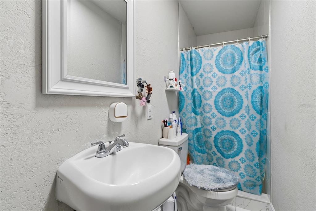 7403 Spring Court Tampa, FL 33634 - Photo 77 of 100 a bathroom with a sink and mirror with toilet