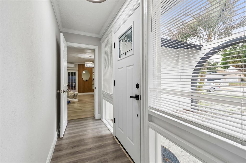 7403 Spring Court Tampa, FL 33634 - Photo 9 of 100 a view of a hallway with wooden floor and windows