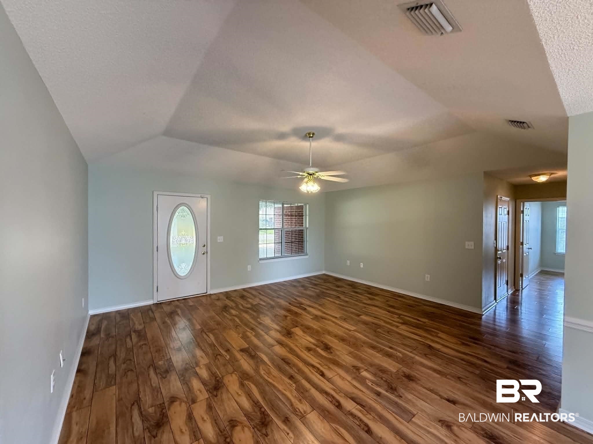 123 Pennbrooke Loop Foley, AL 36535 - Photo 15 of 49 Spacious interior featuring wood-finish flooring, vaulted ceilings, and light blue wall tones