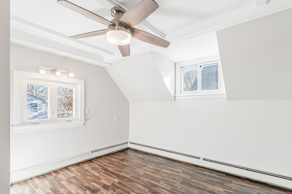 5 Sherbrook Place Lynn, MA 01904 - Photo 17 of 34 an empty room with wooden floor chandelier fan and windows