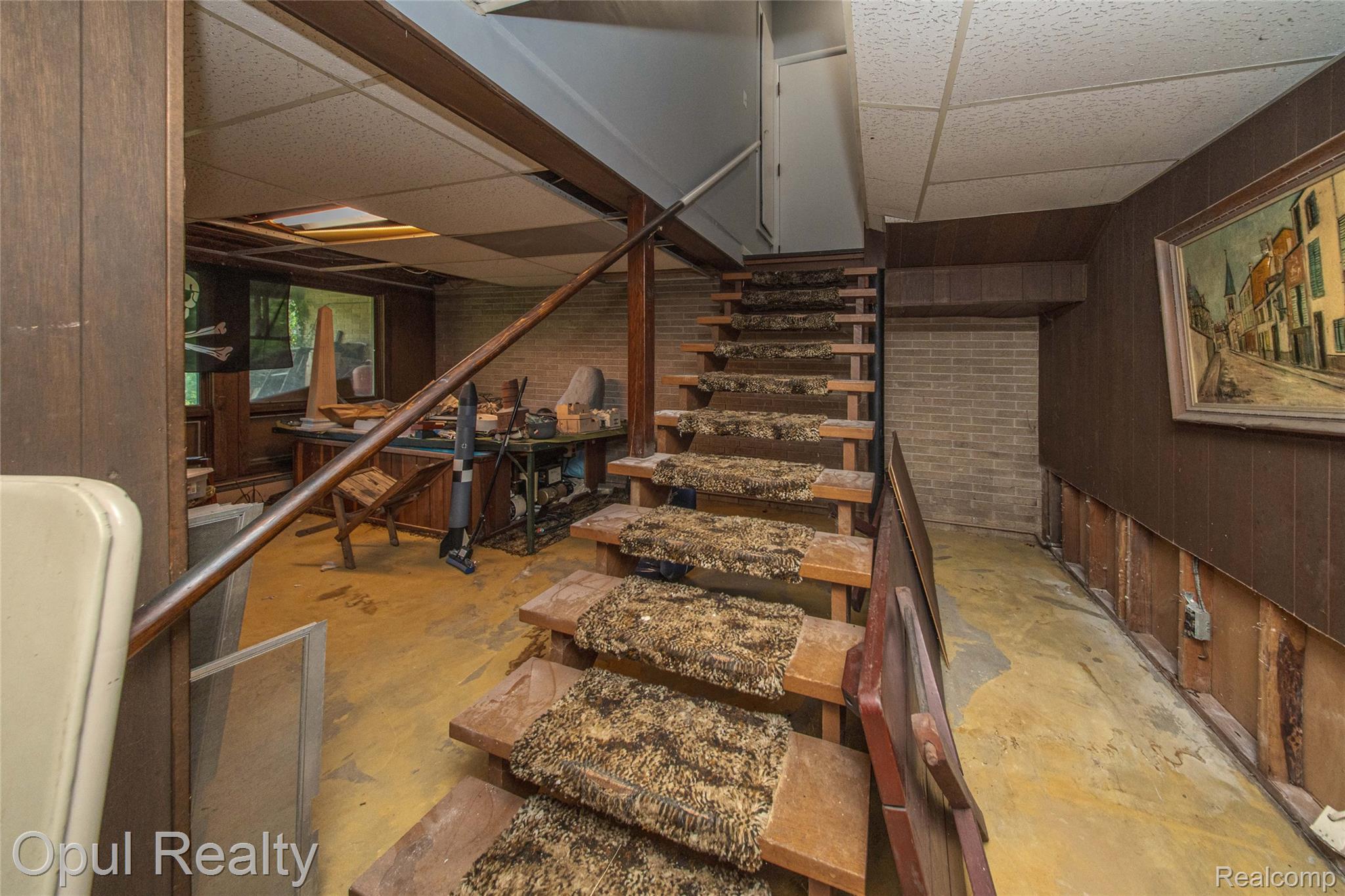 6455 Norham Road Bloomfield Hills, MI 48301 - Photo 60 of 93 Staircase with wood treads and a wood handrail, featuring wood paneling and exposed brick elements