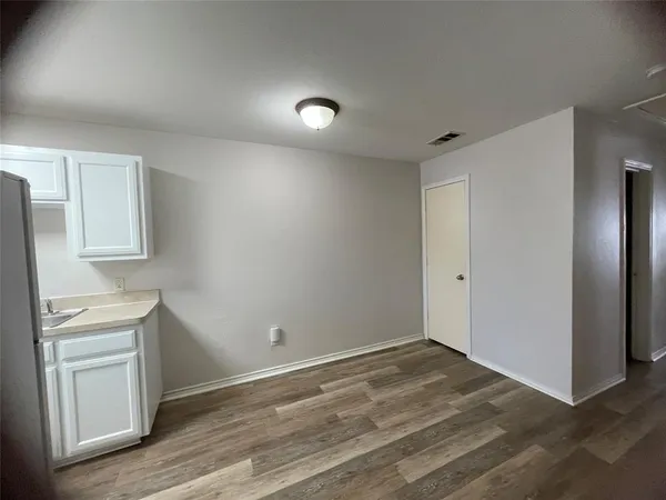 a room with a wooden floor and white walls