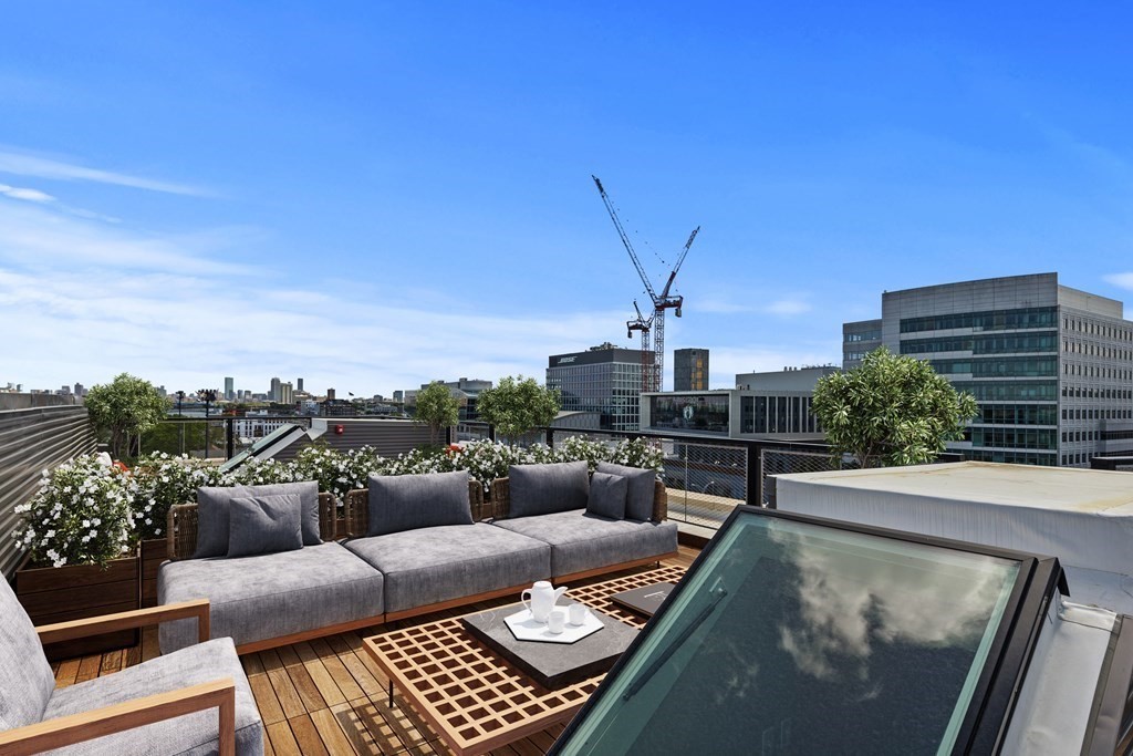 a view of roof deck with couches and wooden floor