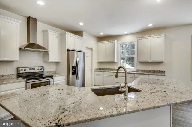 a kitchen with stainless steel appliances granite countertop a sink a stove and a refrigerator