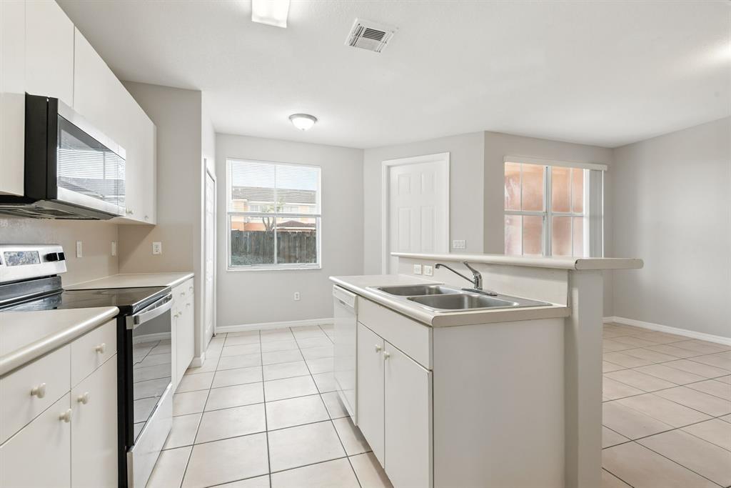 24055 Southwest 109th Court Homestead, FL 33032 - Photo 14 of 42 a kitchen with a sink stove and cabinets