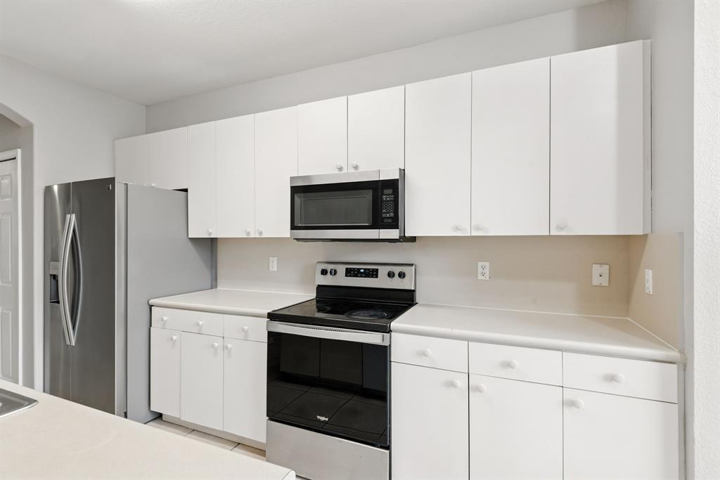 24055 Southwest 109th Court Homestead, FL 33032 - Photo 15 of 42 a kitchen with white cabinets and stainless steel appliances