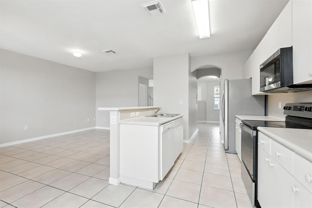24055 Southwest 109th Court Homestead, FL 33032 - Photo 16 of 42 a kitchen with stainless steel appliances granite countertop a stove a sink and a refrigerator