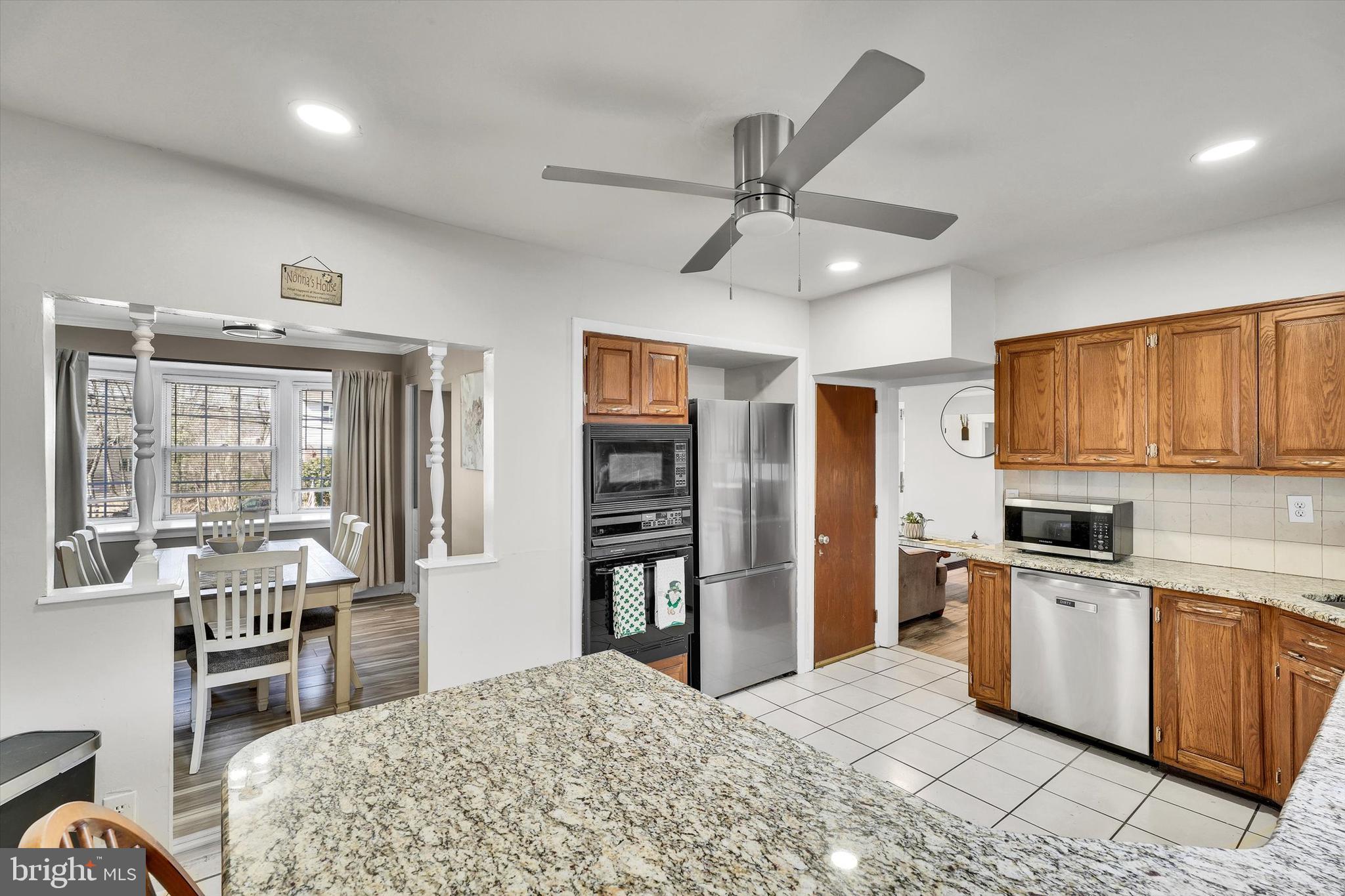 13497 Trevose Road Philadelphia, PA 19116 - Photo 14 of 34 a kitchen with stainless steel appliances kitchen island granite countertop a refrigerator a stove top oven a sink dishwasher and a dining table with wooden floor