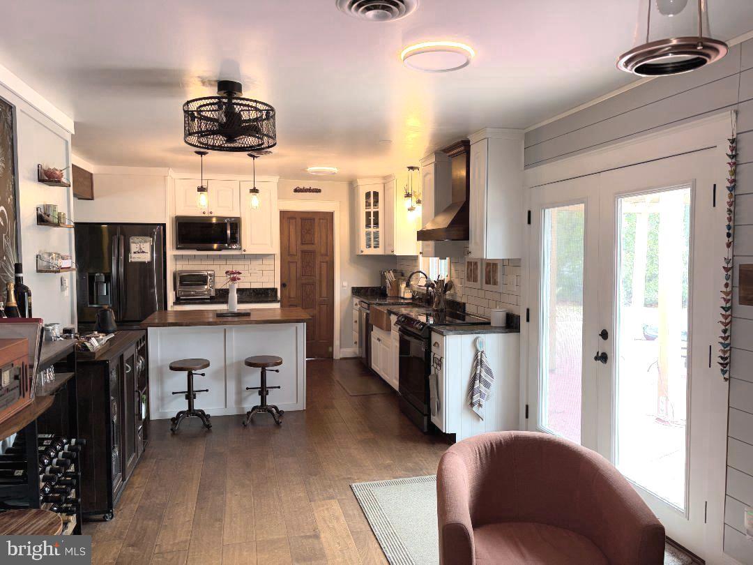 2615 Whitt Road Kingsville, MD 21087 - Photo 5 of 45 a kitchen with stainless steel appliances kitchen island granite countertop a refrigerator a stove a sink dishwasher and white cabinets with wooden floor