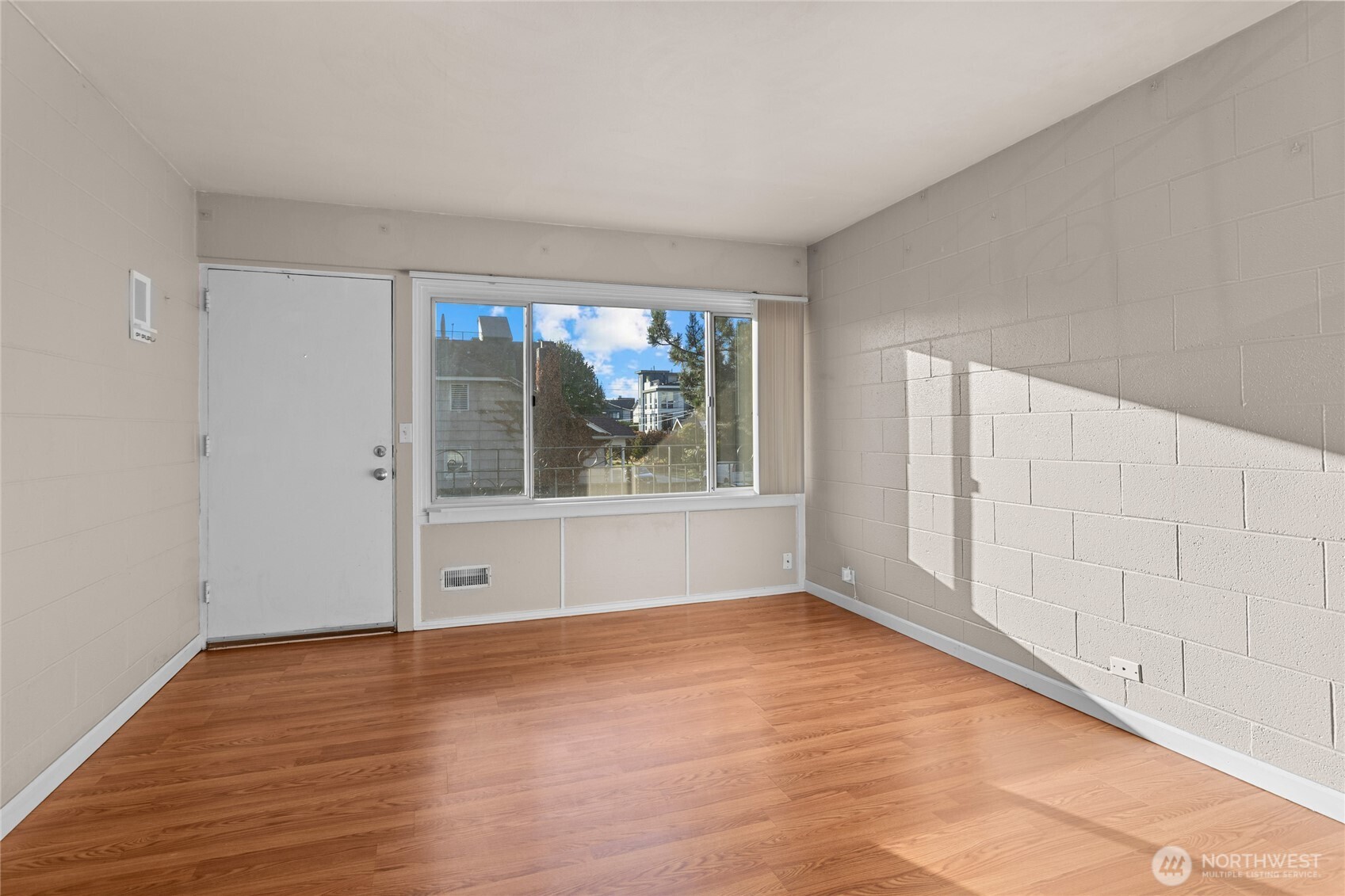 801 Northwest 54th Street Seattle, WA 98107 - Photo 12 of 25 a view of an empty room with wooden floor and a window