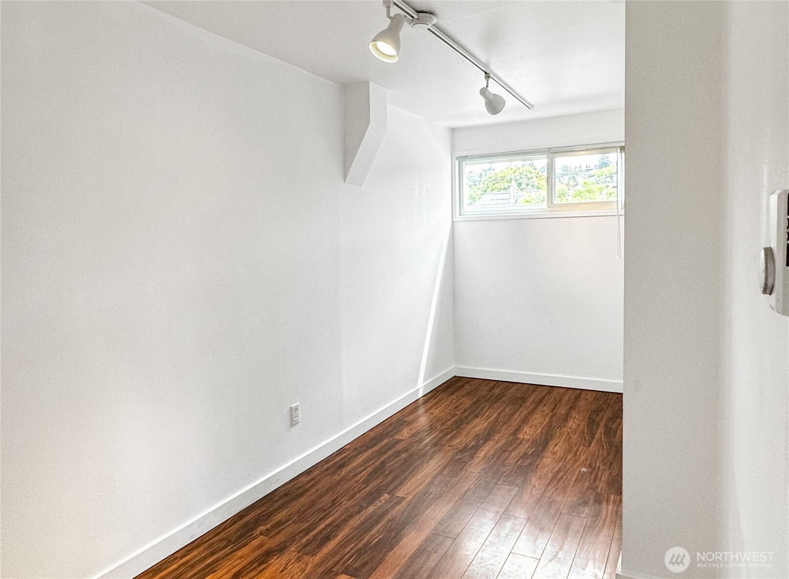 801 Northwest 54th Street Seattle, WA 98107 - Photo 2 of 25 a view of an empty room with wooden floor and a window