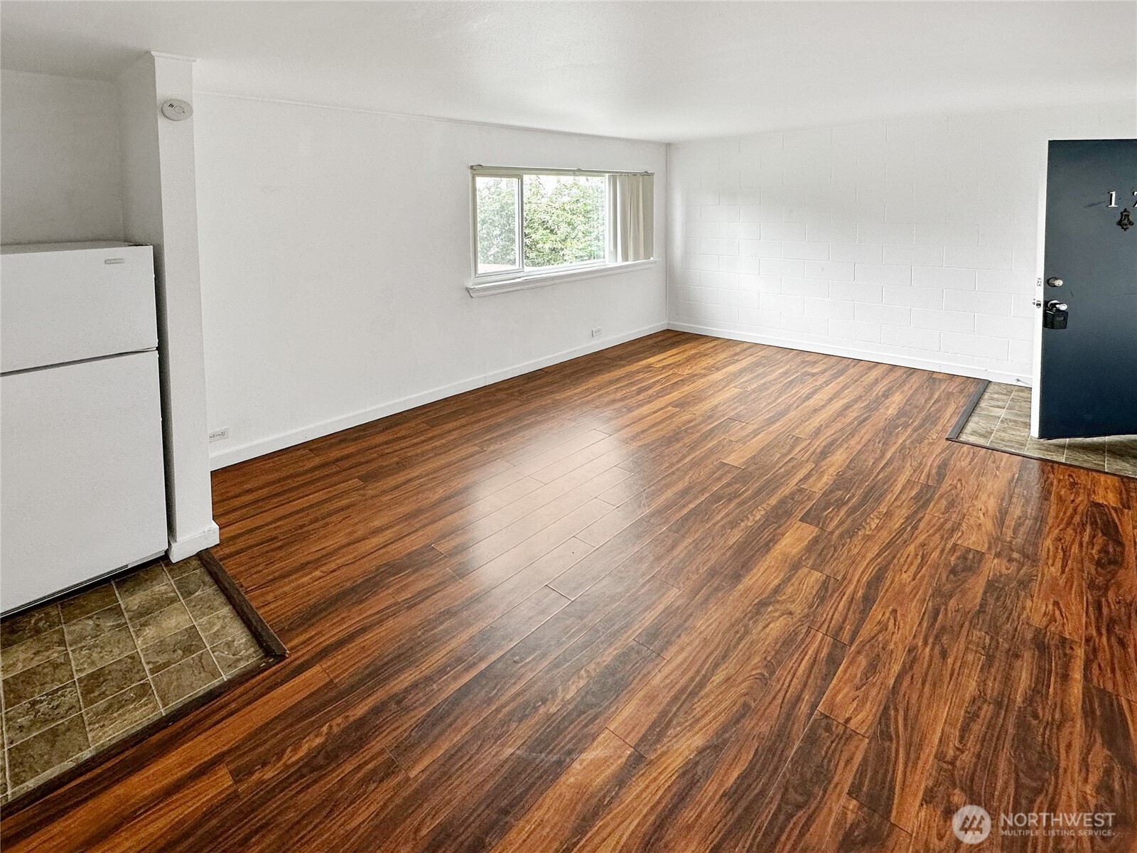 801 Northwest 54th Street Seattle, WA 98107 - Photo 4 of 25 a view of an empty room with wooden floor and a window