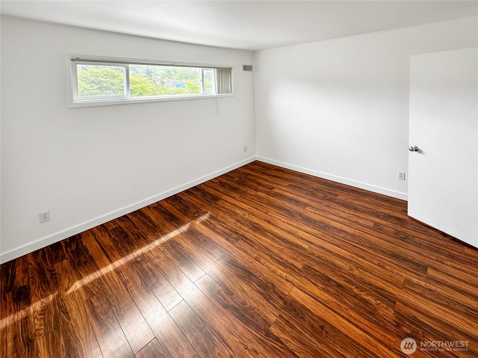 801 Northwest 54th Street Seattle, WA 98107 - Photo 7 of 25 a view of a room with wooden floor and a window