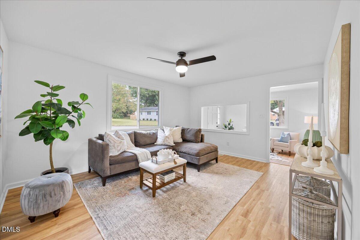 3437 Apache Drive Raleigh, NC 27609 - Photo 11 of 40 Living area with LVP flooring, a ceiling fan, and white walls