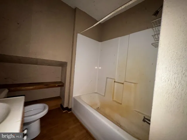 a bathroom with a tub and toilet