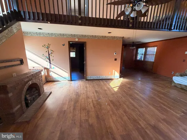 en empty room with wooden floor and windows