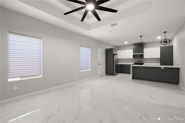 a view of kitchen with kitchen island stainless steel appliances wooden floor cabinets and window
