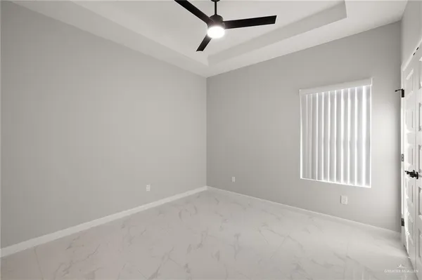 an empty room with windows and fan