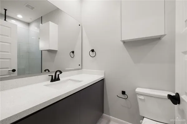 a bathroom with a sink a toilet and a mirror