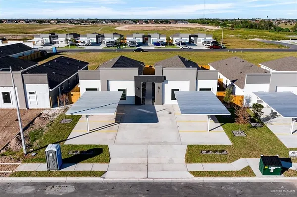 an aerial view of residential houses with outdoor space and ocean view
