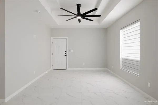 an empty room with windows and fan