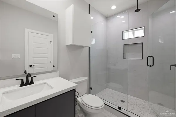 a bathroom with a sink a toilet and shower