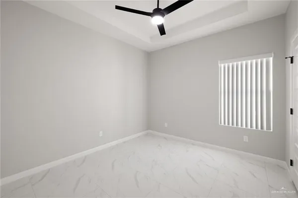 an empty room with a window and a ceiling fan