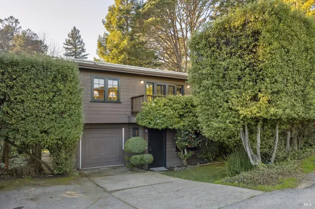 a yellow house with trees in front of it
