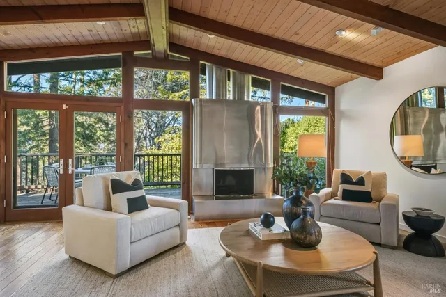 a living room with furniture a fireplace and a large window