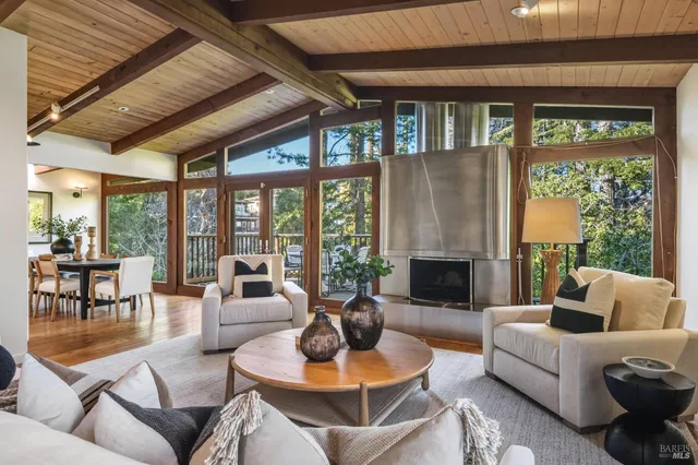 a living room with furniture a large window and a fireplace