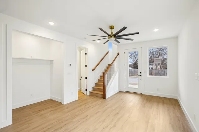 a view of a hallway with wooden floor and staircase