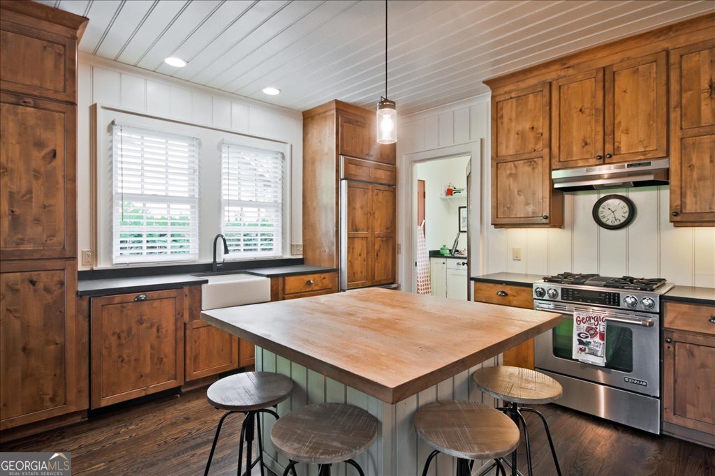 109 Coneflower Lane Toccoa, GA 30577 - Photo 12 of 49 a kitchen with stainless steel appliances granite countertop a stove a refrigerator a sink a dining table and chairs with wooden floor