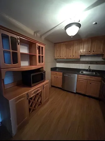 a kitchen with stainless steel appliances granite countertop a stove a sink and a microwave
