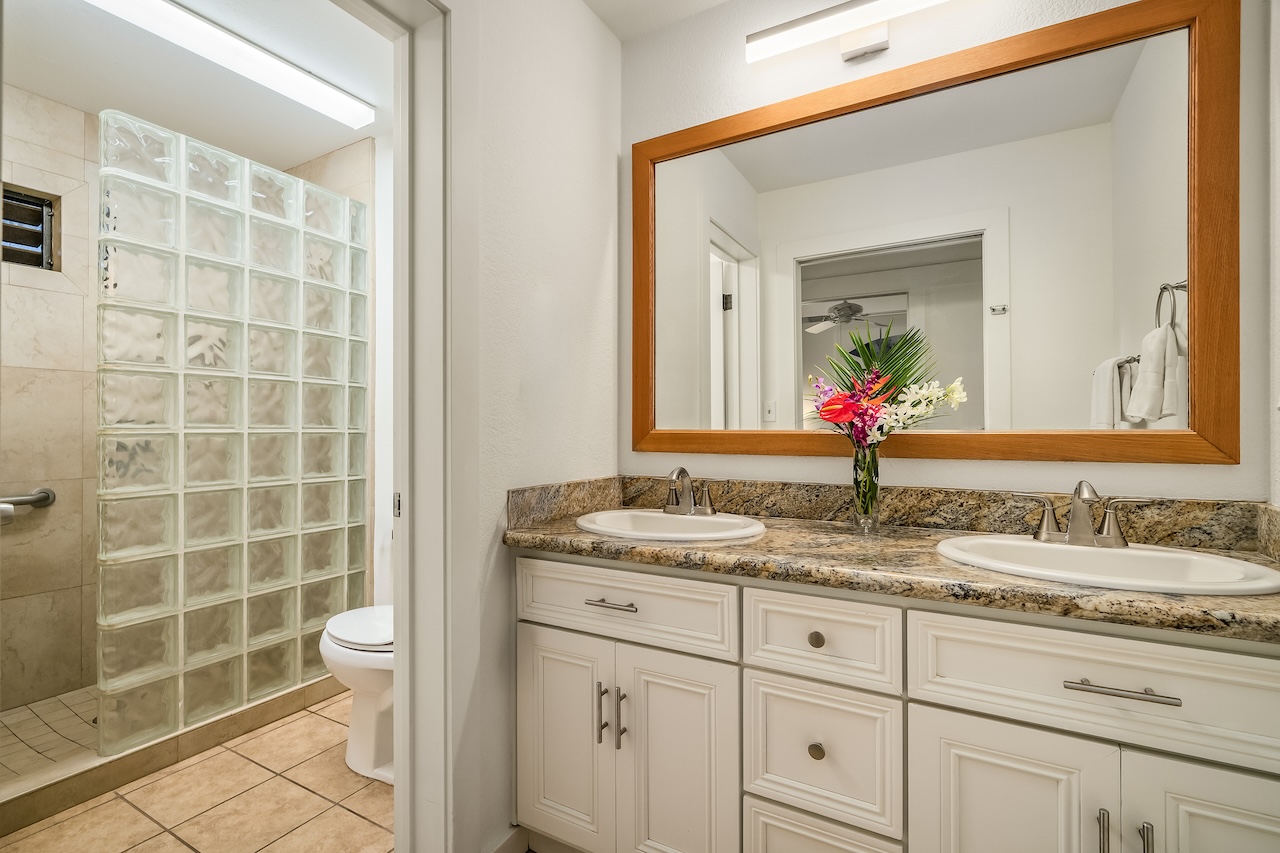 2253 Poipu Road, Unit 440 Koloa, HI 96756 - Photo 16 of 24 a bathroom with a granite countertop sink a toilet a mirror and shower