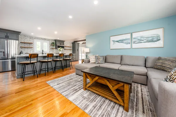 a living room with furniture a flat screen tv and a large window