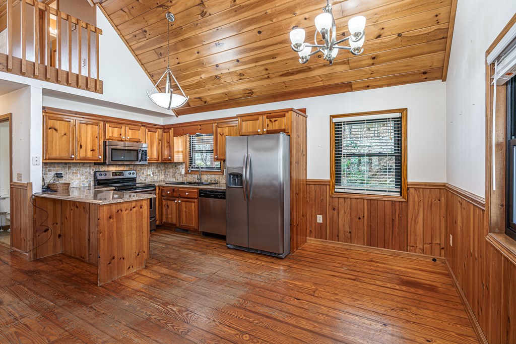 41 Carvers Vw Trail Murphy, NC 28906 - Photo 9 of 46 a kitchen with stainless steel appliances granite countertop a refrigerator a sink dishwasher a stove and a dining table with wooden floor