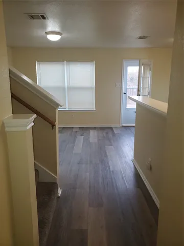wooden floor in an empty room with a kitchen