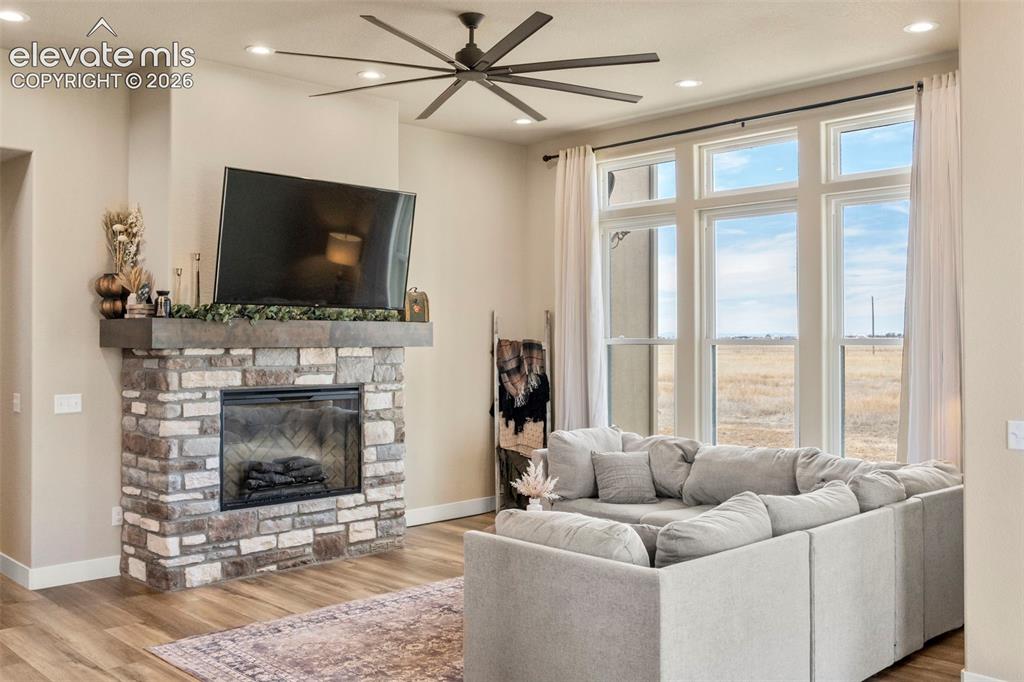 2480 North Log Road Calhan, CO 80808 - Photo 14 of 50 Living area features stone fireplace and ceiling fan