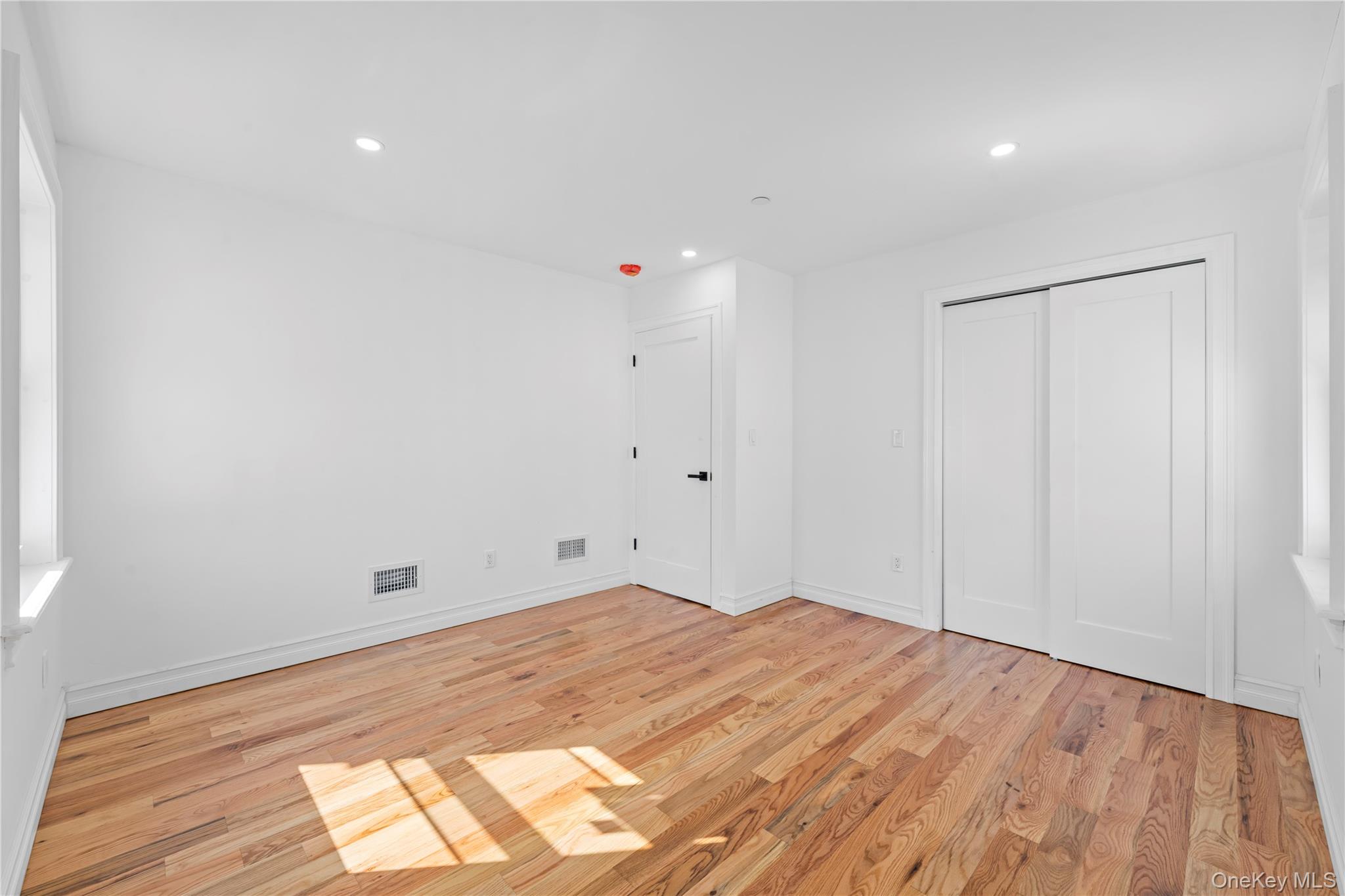 258-14 147th Road Queens, NY 11422 - Photo 10 of 22 Unfurnished bedroom with recessed lighting, light wood-style flooring, and a closet