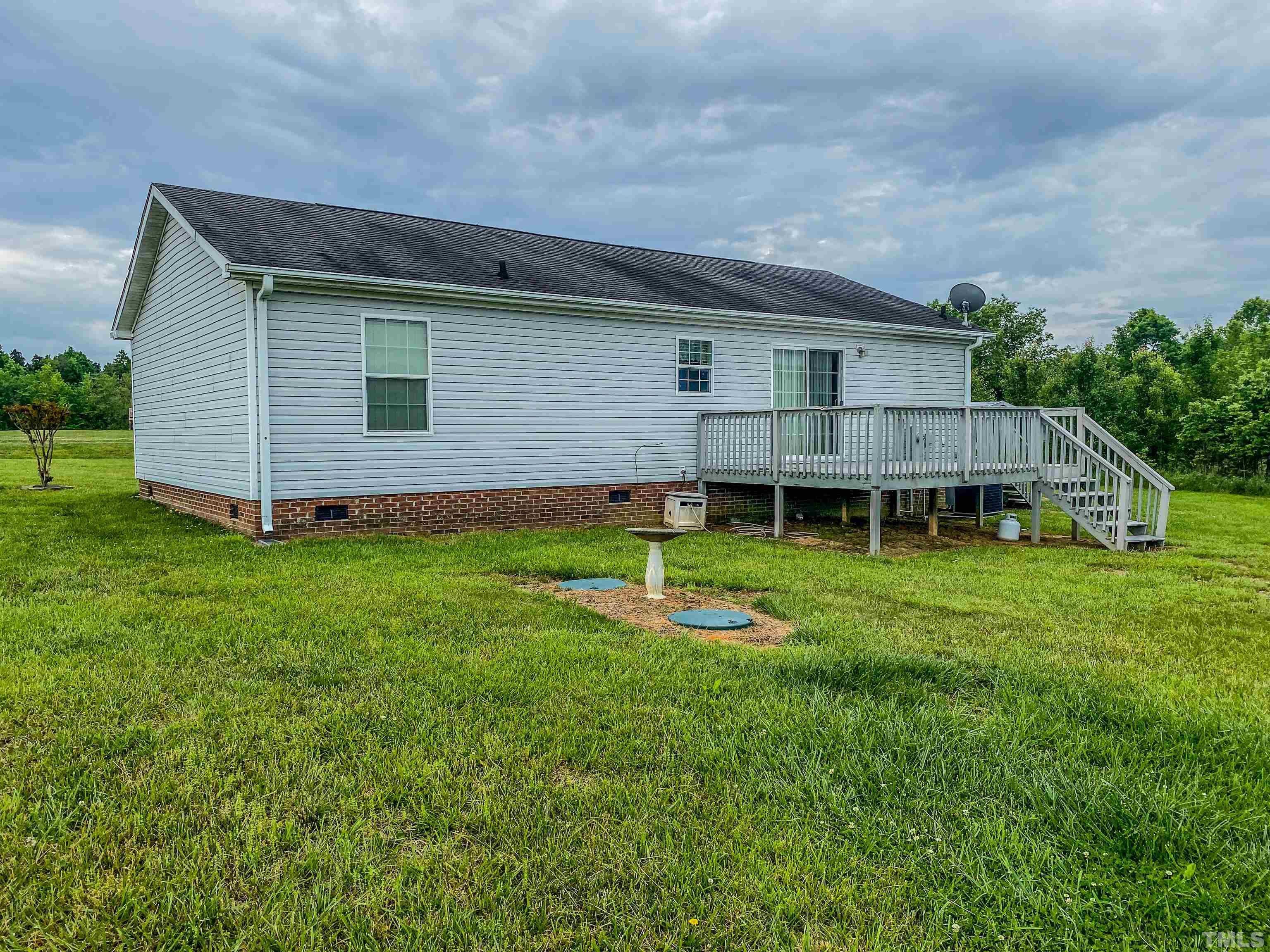147 Quartergate Road Roxboro, NC 27574 - Photo 16 of 30 a backyard of a house with wooden fence and a yard
