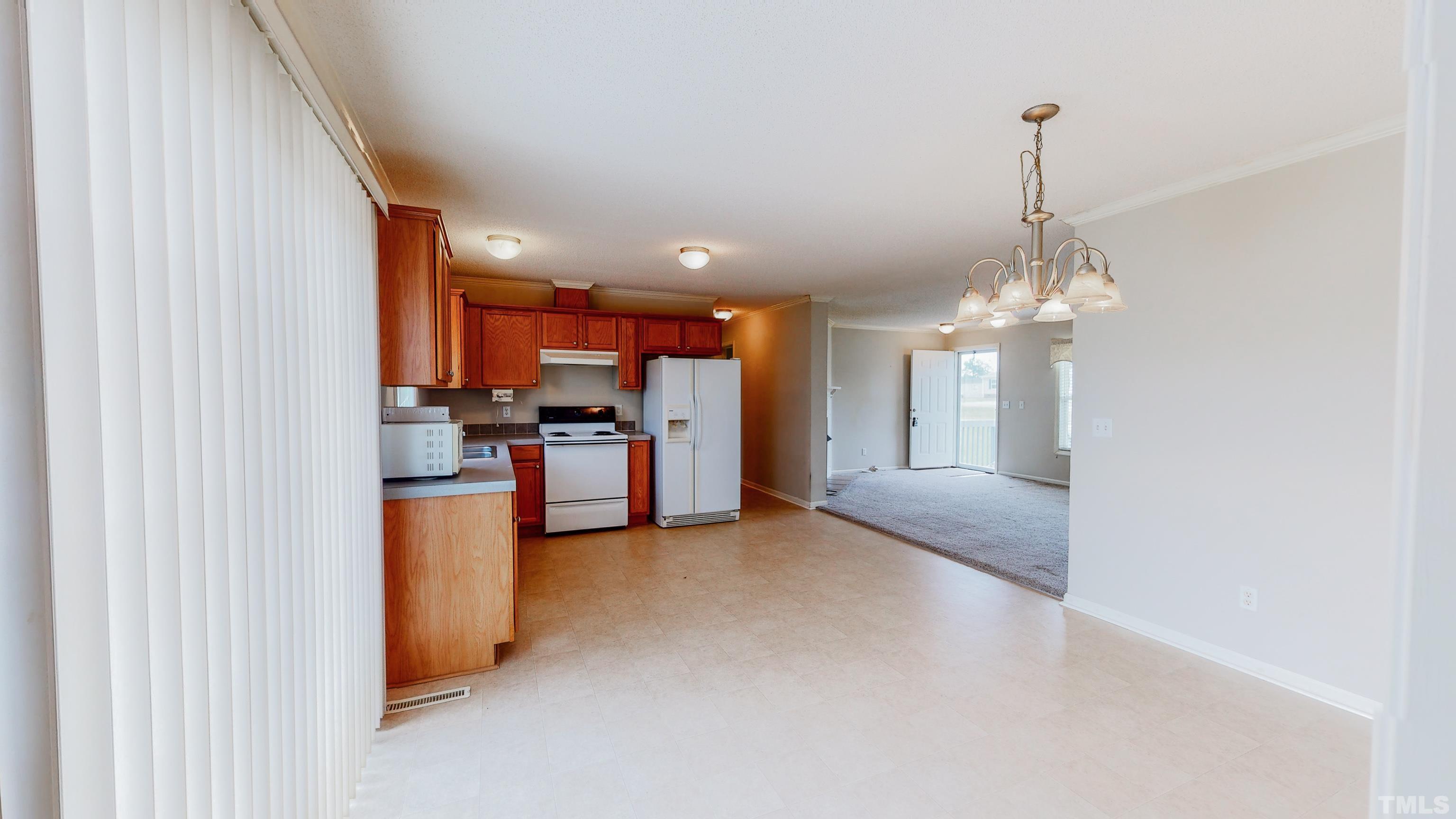 147 Quartergate Road Roxboro, NC 27574 - Photo 19 of 30 a view of a kitchen with refrigerator and cabinets