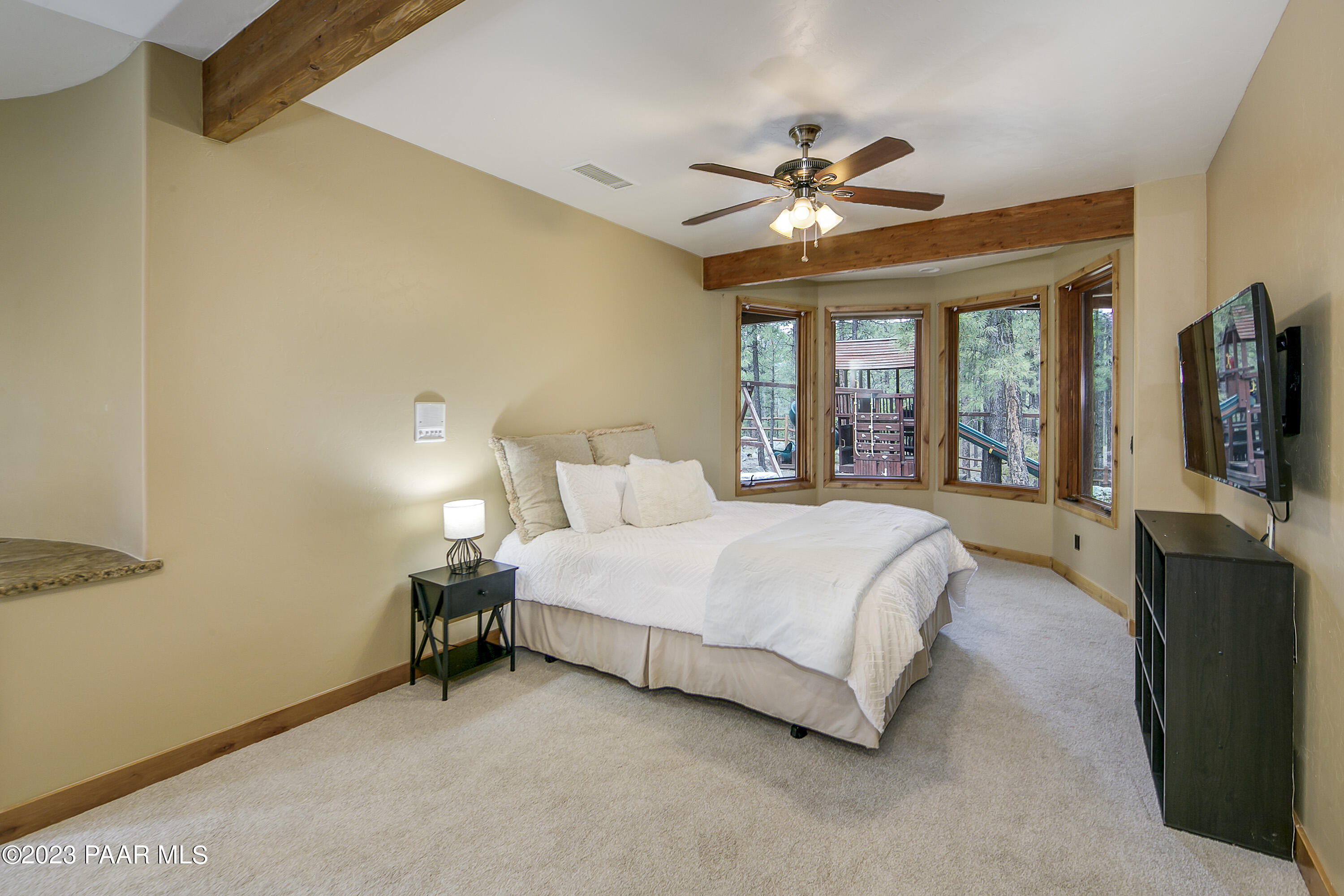 5140 East Charcoal Kiln Road Prescott, AZ 86303 - Photo 37 of 77 a bedroom with a large bed and a flat tv screen on dresser