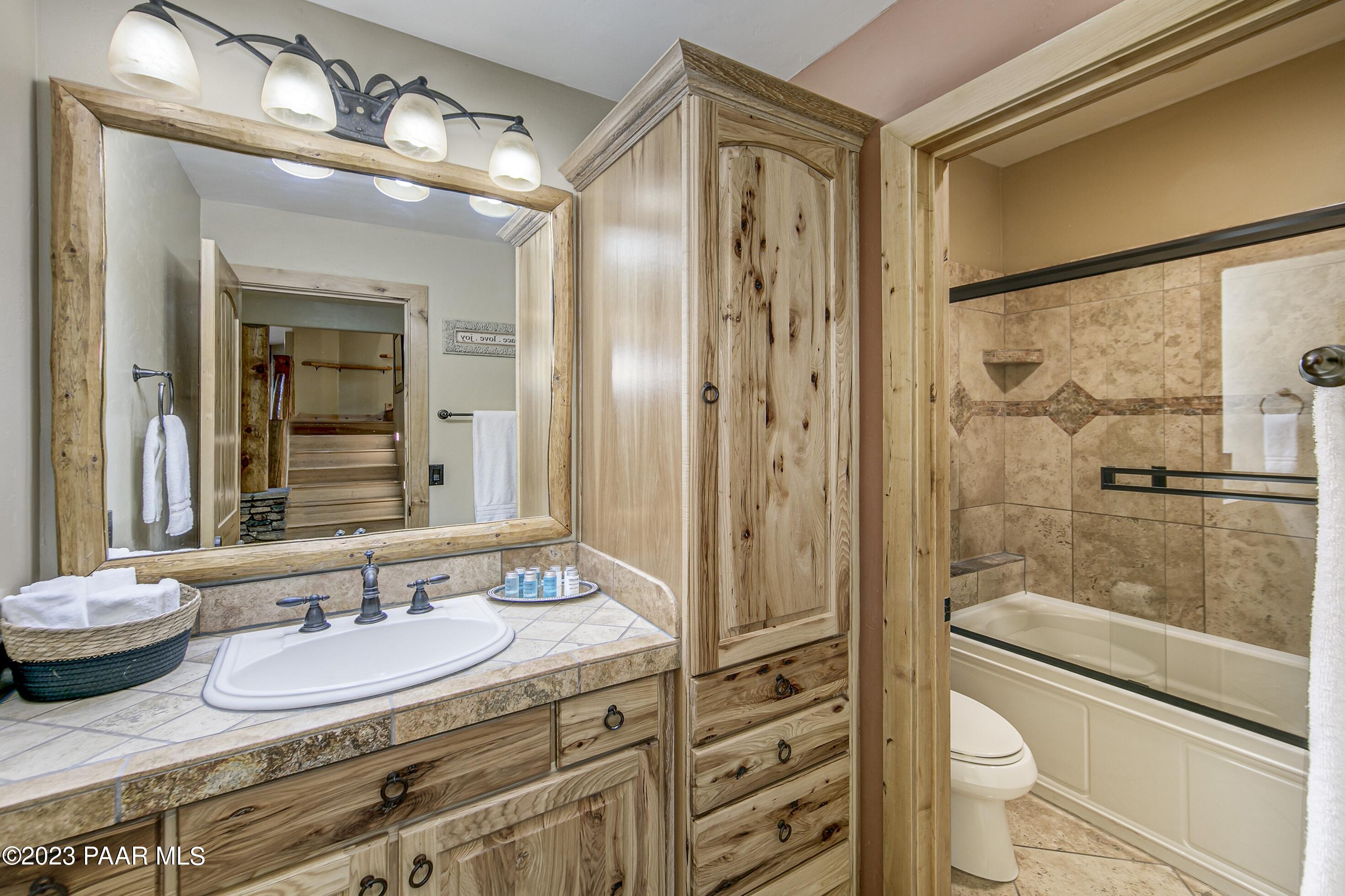 5140 East Charcoal Kiln Road Prescott, AZ 86303 - Photo 41 of 77 a bathroom with a double vanity sink toilet mirror and shower