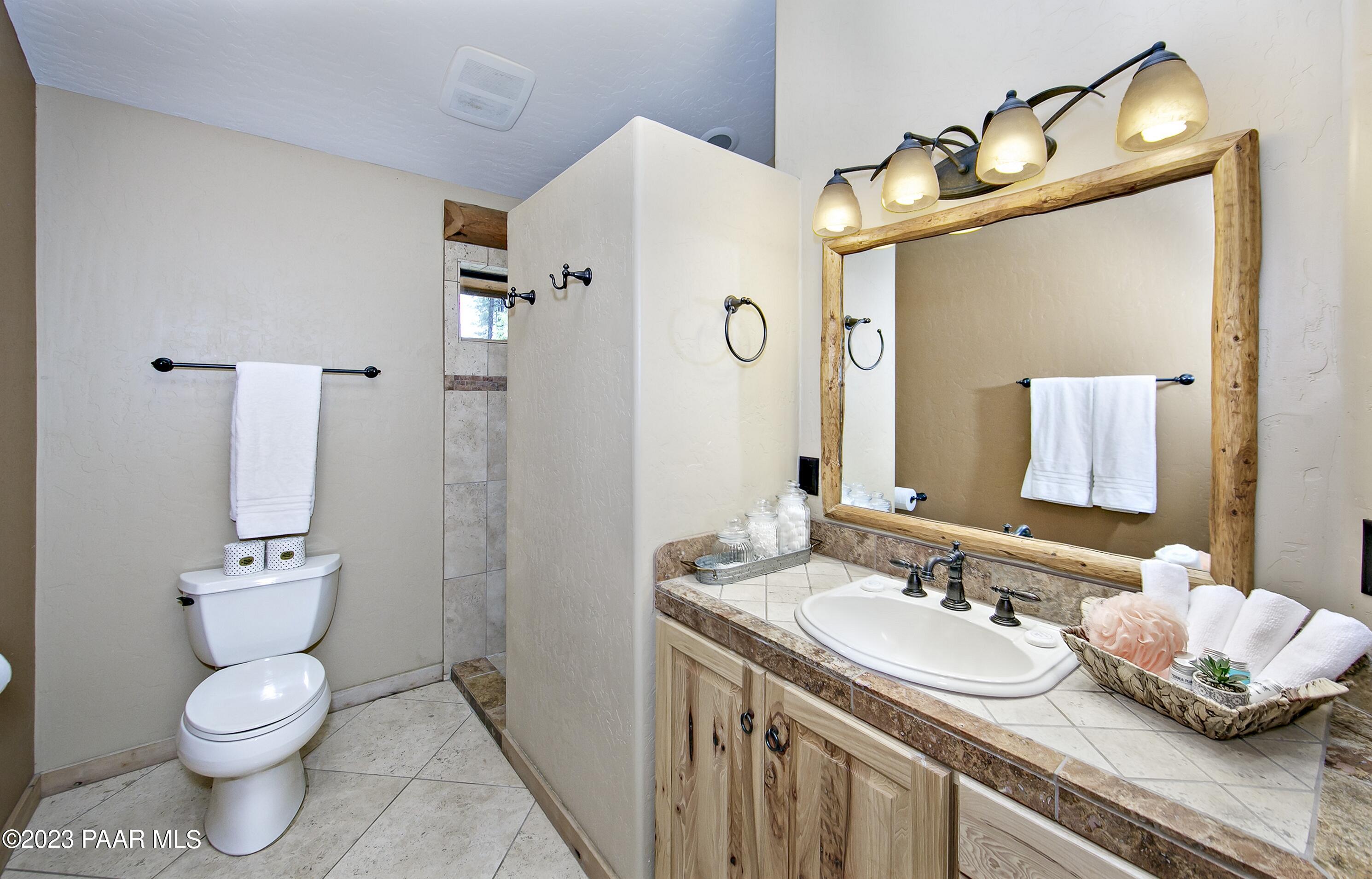 5140 East Charcoal Kiln Road Prescott, AZ 86303 - Photo 68 of 77 a bathroom with a granite countertop sink toilet and shower