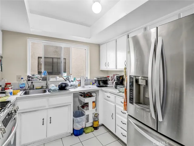 a kitchen with white cabinets and white appliances