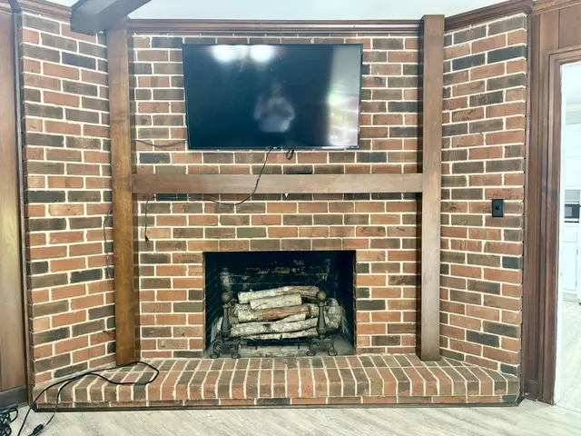 a living room with a fireplace and a flat screen tv