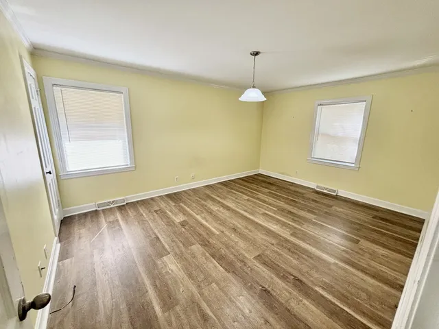 wooden floor in an empty room with a window