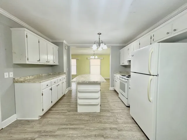 a kitchen with white cabinets and white appliances